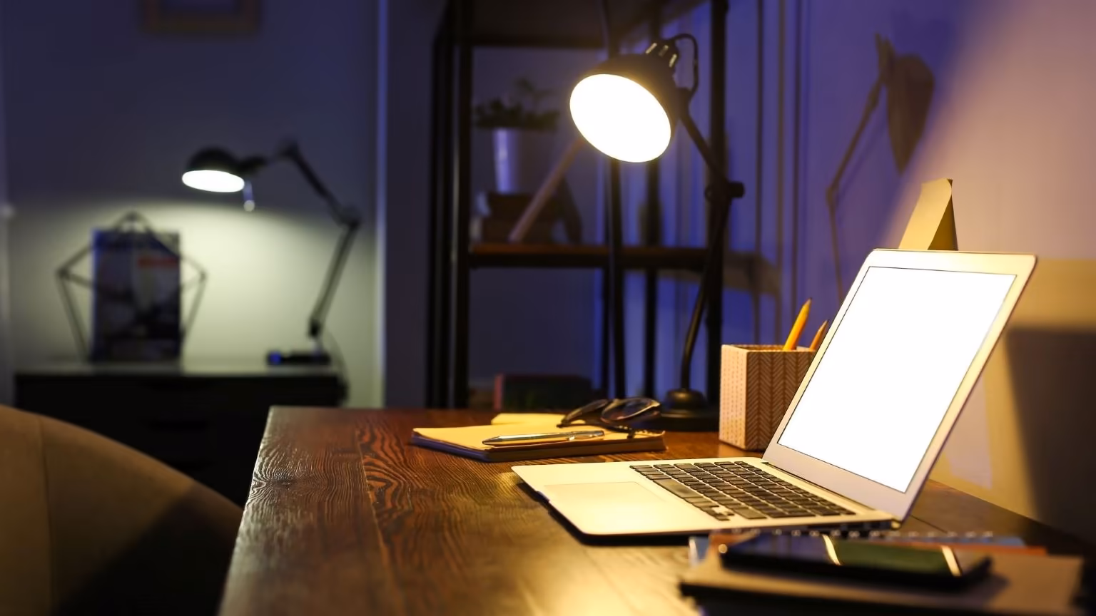 Laptop on a desk in a dark room