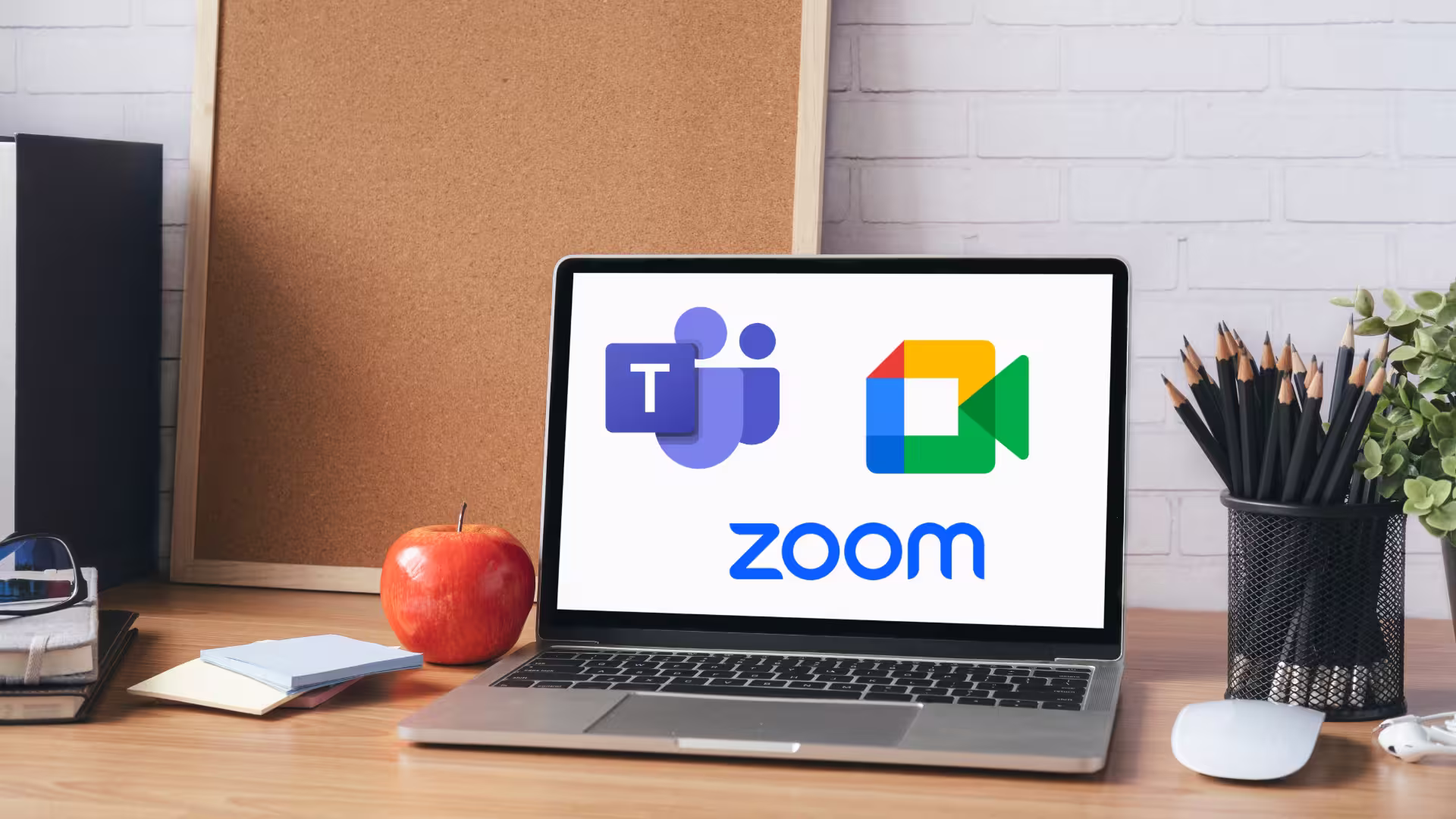 Ein Laptop auf einem Schreibtisch, auf dem verschiedene Videokonferenz-Toos wie Zoom, Teams und Google Meet zu sehen sind